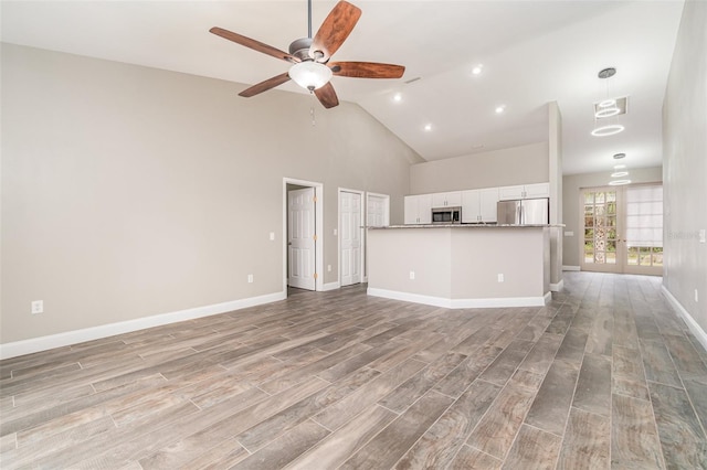 unfurnished living room featuring ceiling fan, french doors, and high vaulted ceiling