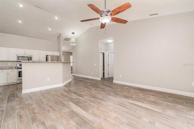 unfurnished living room with high vaulted ceiling and ceiling fan