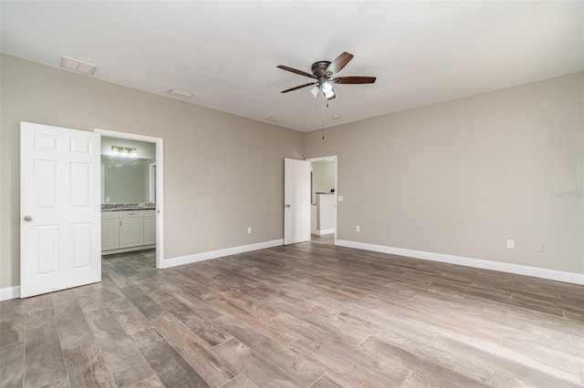 unfurnished bedroom with ensuite bathroom and ceiling fan