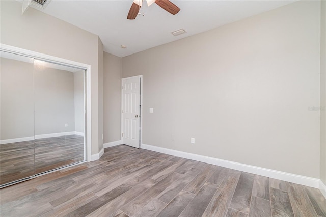 unfurnished bedroom featuring ceiling fan, light hardwood / wood-style flooring, and a closet