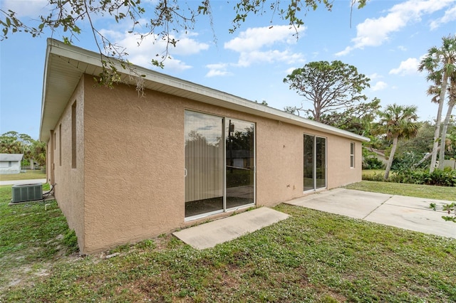 rear view of house featuring central air condition unit, a yard, and a patio