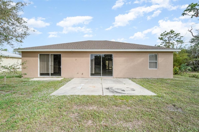 rear view of house with a lawn and a patio area