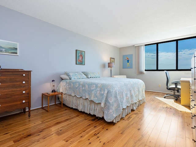 bedroom with baseboards and light wood finished floors