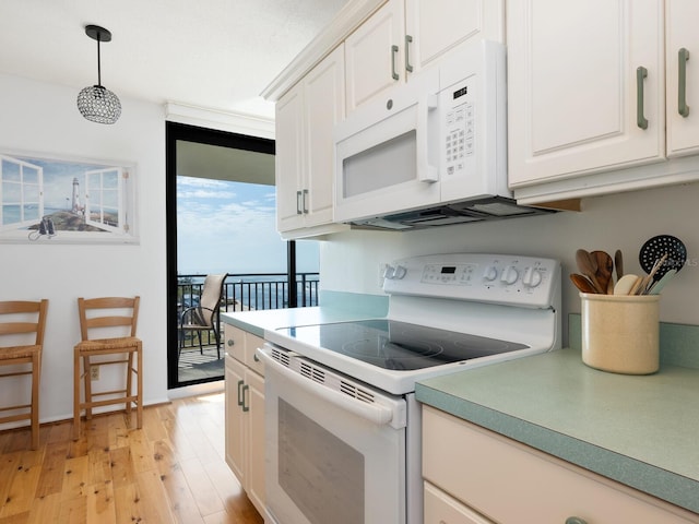 kitchen with light wood-style flooring, white appliances, white cabinets, hanging light fixtures, and light countertops