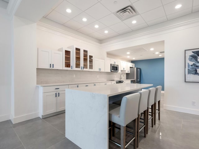 kitchen featuring appliances with stainless steel finishes, light countertops, white cabinetry, and a kitchen island