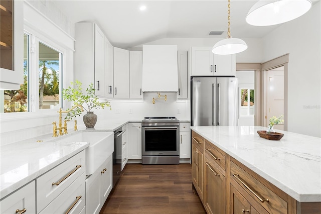 kitchen with light stone counters, tasteful backsplash, white cabinets, appliances with stainless steel finishes, and sink