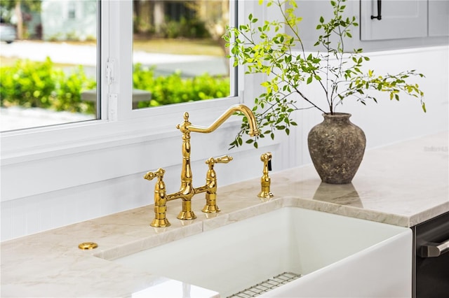 room details featuring sink, dishwasher, and light stone counters