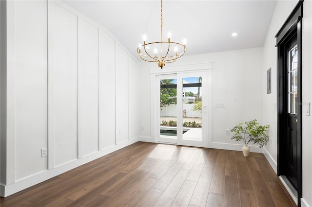 unfurnished room with dark wood-type flooring and a chandelier