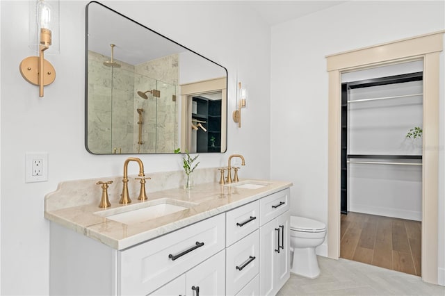 bathroom with hardwood / wood-style floors, an enclosed shower, vanity, and toilet