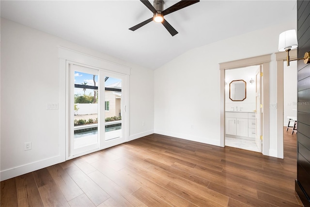 empty room with ceiling fan, lofted ceiling, and hardwood / wood-style flooring