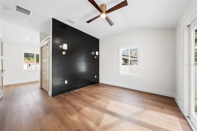 unfurnished room with ceiling fan, light wood-type flooring, vaulted ceiling, and plenty of natural light