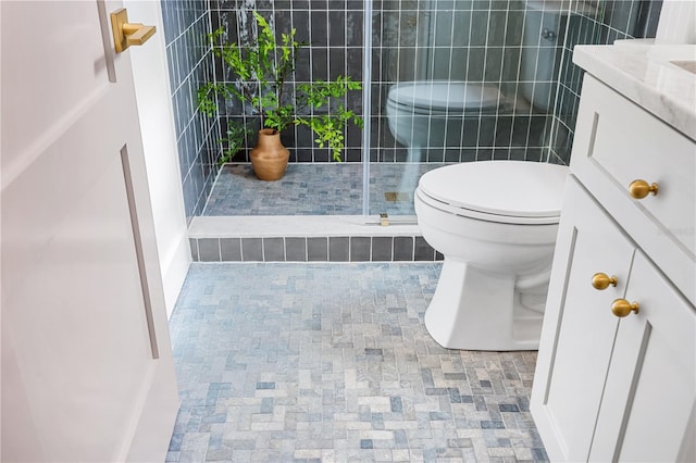 bathroom featuring toilet, an enclosed shower, and vanity