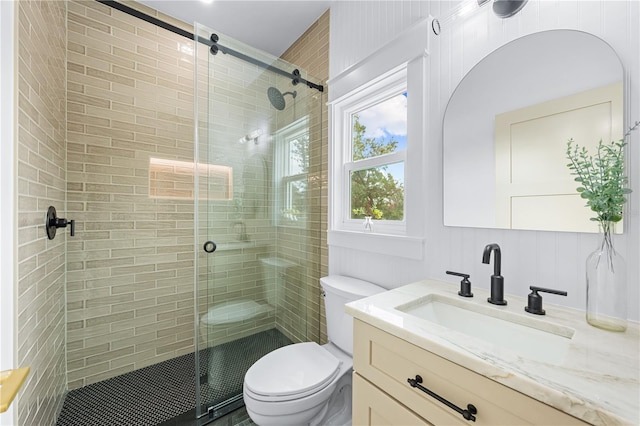 bathroom with toilet, an enclosed shower, and vanity