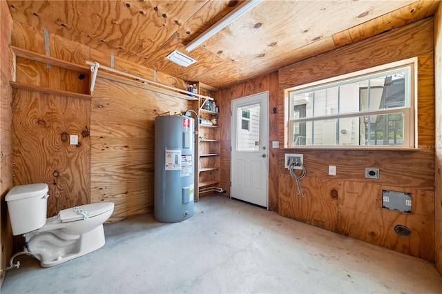 interior space featuring water heater and wood walls