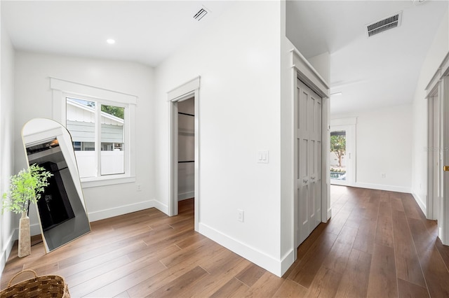 corridor with lofted ceiling and hardwood / wood-style flooring