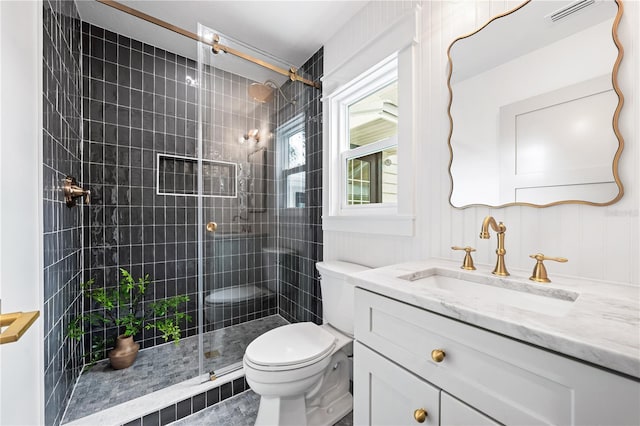 bathroom featuring toilet, a shower with door, and vanity