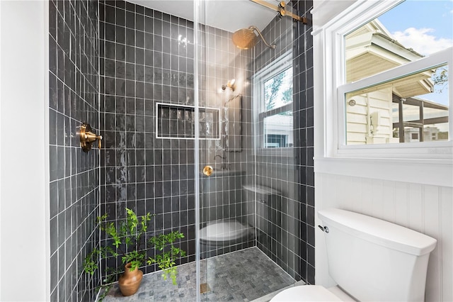 bathroom featuring toilet and a tile shower