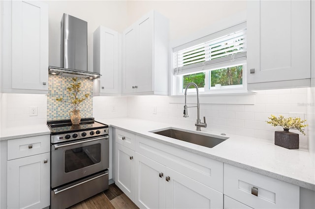 kitchen featuring sink, white cabinets, electric stove, light stone countertops, and wall chimney range hood