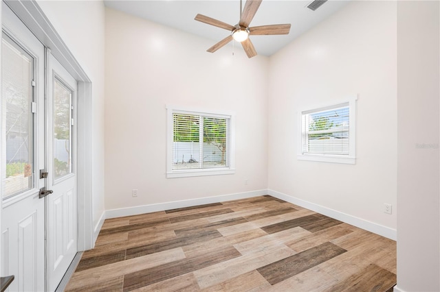 unfurnished room with high vaulted ceiling, ceiling fan, and light hardwood / wood-style flooring