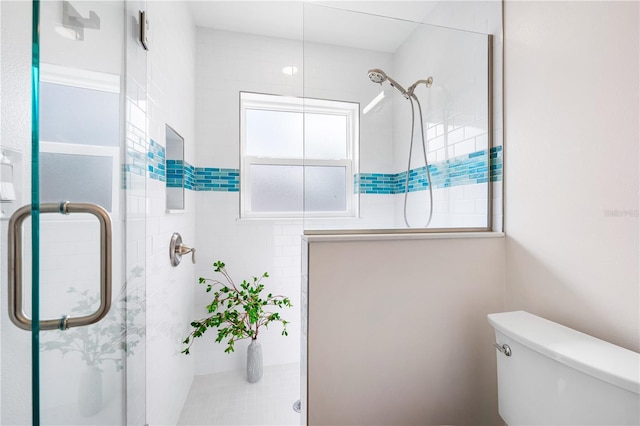 bathroom with a wealth of natural light, an enclosed shower, and toilet