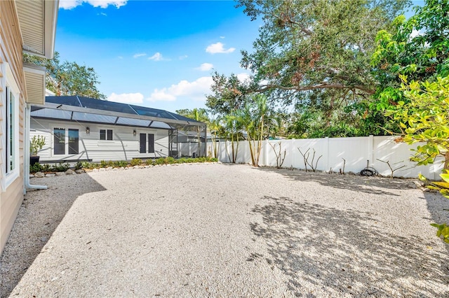 view of yard featuring glass enclosure and a patio area