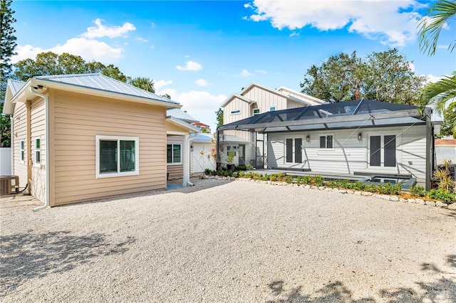 rear view of property featuring a lanai, a patio, and central AC