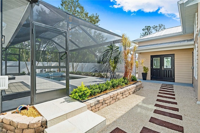 view of patio / terrace featuring a lanai, a fenced in pool, and french doors