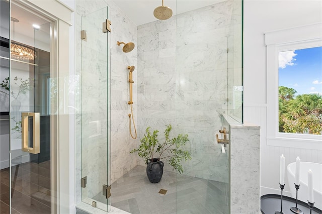 bathroom with a stall shower, wainscoting, and a freestanding bath