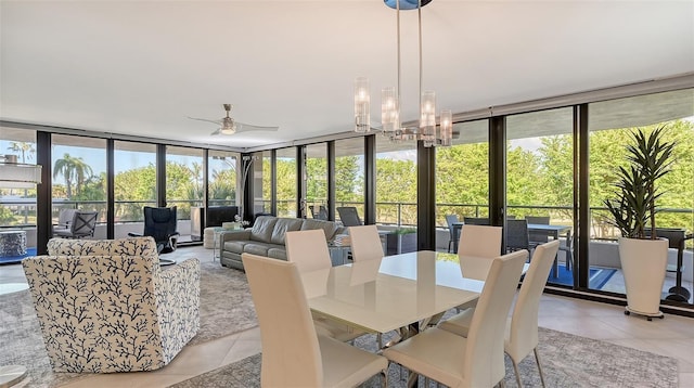 tiled dining area featuring ceiling fan with notable chandelier, a healthy amount of sunlight, and a wall of windows