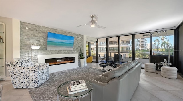 tiled living room with ceiling fan and a large fireplace