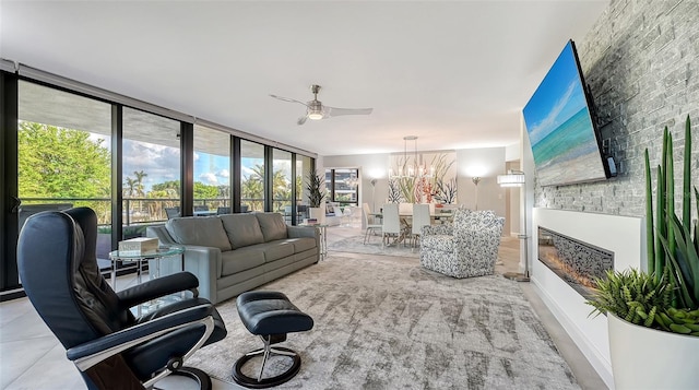 living room featuring ceiling fan with notable chandelier and floor to ceiling windows