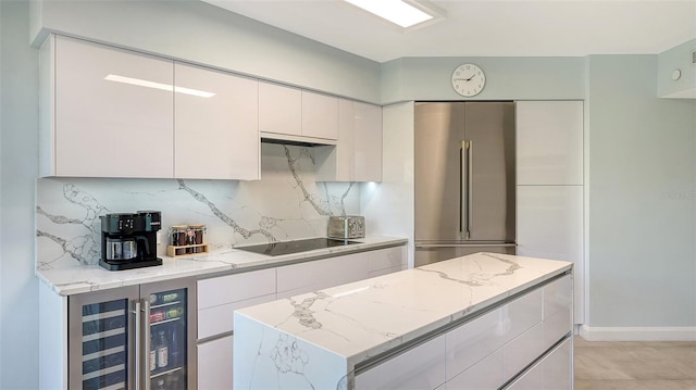 kitchen with white cabinetry, wine cooler, high quality fridge, black electric cooktop, and decorative backsplash