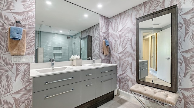 bathroom featuring a shower with door and vanity