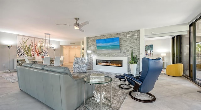 living room featuring ceiling fan with notable chandelier and a fireplace