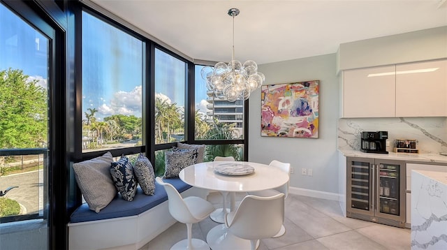 dining space featuring a chandelier, light tile patterned floors, and beverage cooler