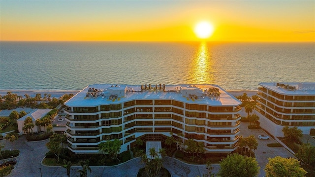 aerial view at dusk featuring a water view