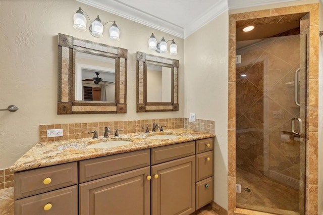 bathroom featuring a shower with shower door, decorative backsplash, vanity, ceiling fan, and crown molding