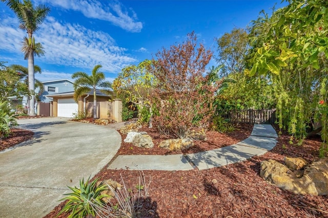 view of property hidden behind natural elements with a garage