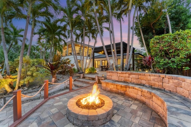 patio terrace at dusk featuring a fire pit