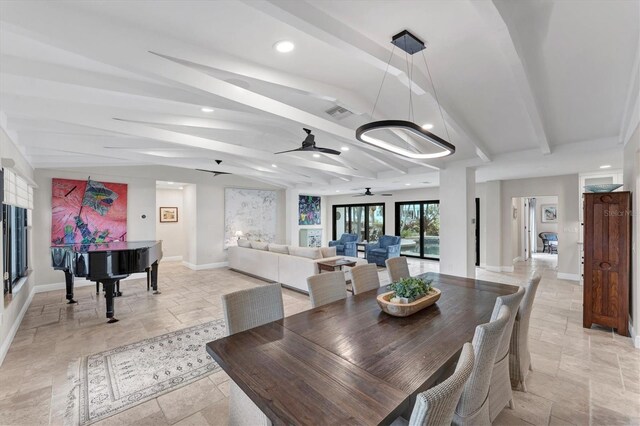 dining room featuring ceiling fan with notable chandelier and lofted ceiling with beams