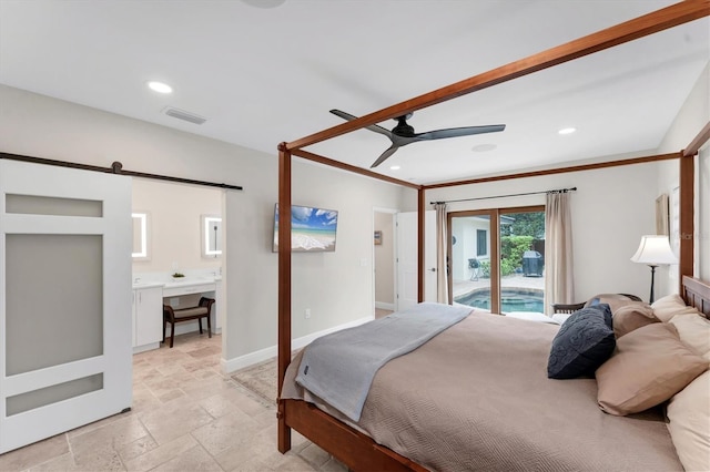 bedroom featuring a barn door, access to outside, ceiling fan, and ensuite bathroom