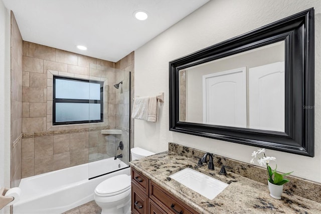 full bathroom featuring tiled shower / bath combo, toilet, and vanity