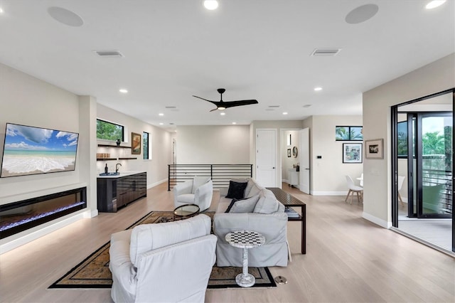 living room featuring ceiling fan and light wood-type flooring