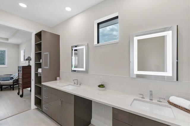 bathroom featuring hardwood / wood-style floors, vanity, and decorative backsplash