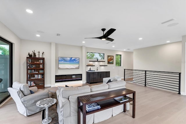 living room featuring ceiling fan and light hardwood / wood-style flooring