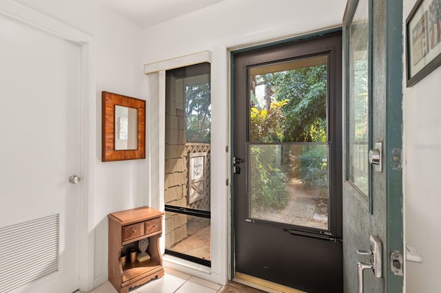 doorway to outside with light tile patterned floors