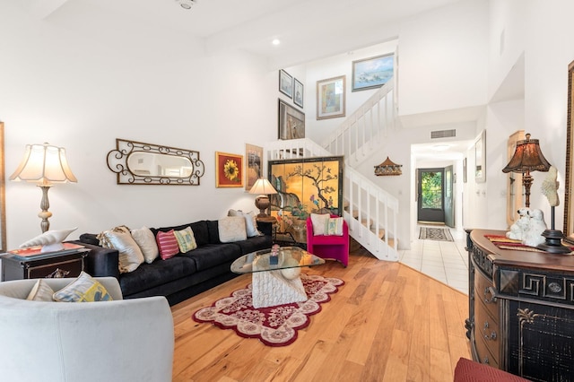 living room with light hardwood / wood-style flooring and a high ceiling