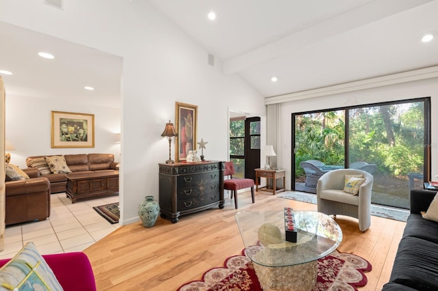 living room featuring vaulted ceiling with beams and light hardwood / wood-style flooring