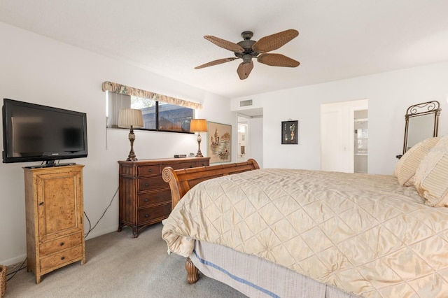 carpeted bedroom with ceiling fan and ensuite bath