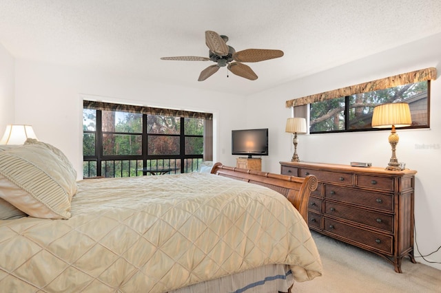 bedroom with a textured ceiling, light colored carpet, and ceiling fan